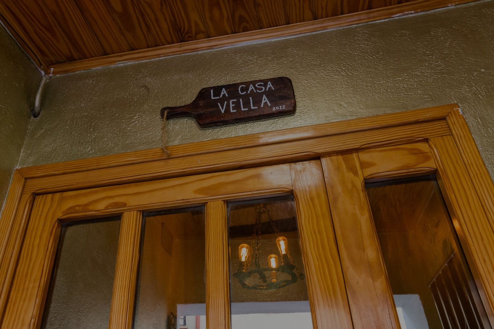 Rètol de fusta de La Casa Vella sobre la porta